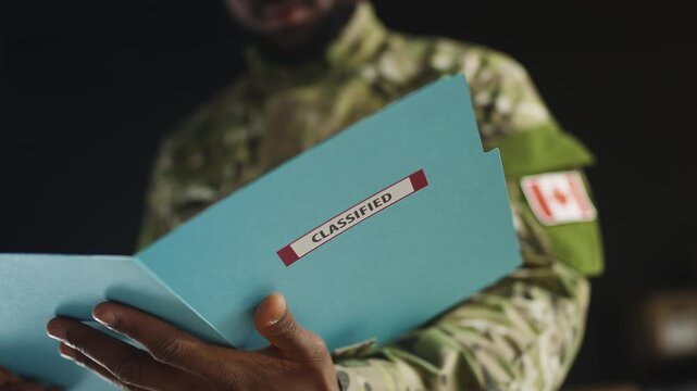 Canadian soldier reviews confidential military reports and top secret documents