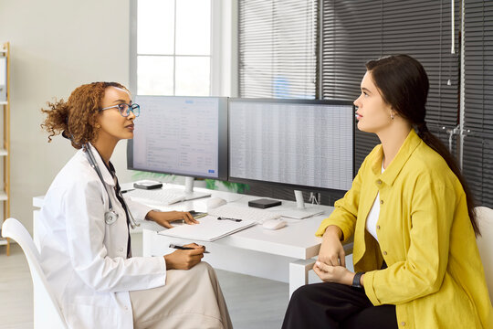 Doctor patient consultation clinic healthcare appointment discussion. Physician and woman review results, discuss symptoms and treatment in a tidy office. Clear trusted medical guidance concept.
