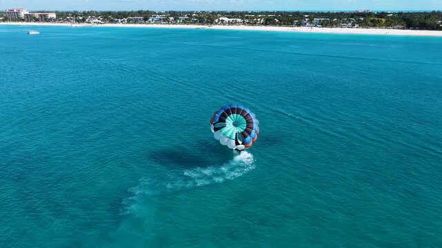 Parasail In Providenciales Overseas Territory Turks And Caicos Islands. Tourists Parasailing Over A Tropical Ocean On A Sunny Day.