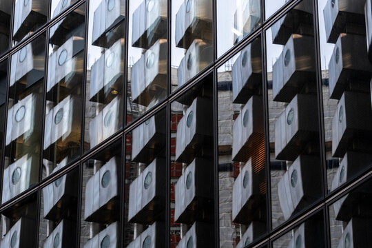 Reflective glass turns a modern architecture facade into a grid, where projecting modules, windows and reflection build a layered pattern through repetition.