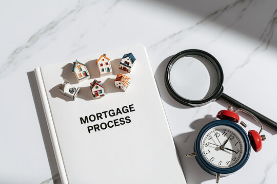 Mortgage process book with small models. Finance concept theme.