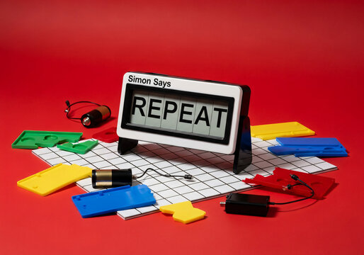 Flip clock displaying REPEAT word with colorful game pieces on red