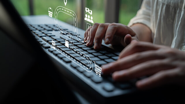 A close-up view of hands typing on a laptop keyboard, accompanied by abstract logistics icons. This visual highlights the fusion of technology and transportation in a creative workspace. Ledger