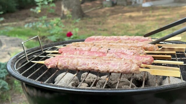 Close up view of grilling meat on hot coals creating flavorful smoke an outdoor backyard barbecue scene enjoying summer cooking together