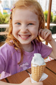 A child enjoys ice cream on a warm day in the park.