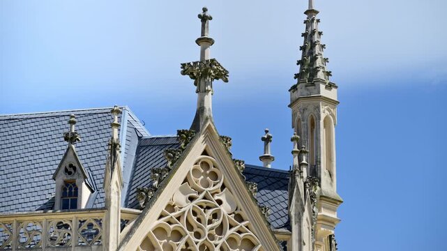 Close-up of a neo-Gothic gable of Lednice Castle with carved stone tracery and pinnacles above a slate roof, Czech Republic