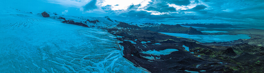 Panoramic aerial view of Vatnajökull Glacier flowing into Iceland's volcanic highlands with rugged...