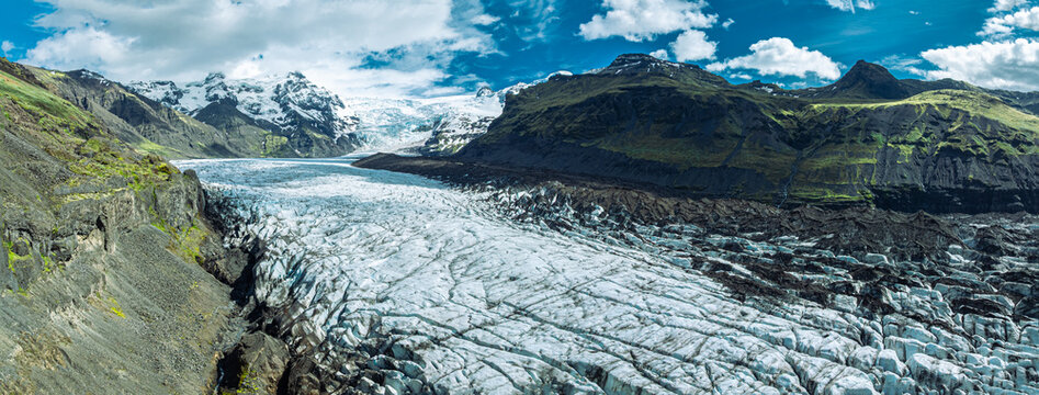 Sharp blue ice formations rise above the glacier lagoon at Skaftafellsj&ouml;kull in Vatnaj&ouml;kull National Park, surrounded by rugged mountains and Iceland's spectacular glacial landscape.