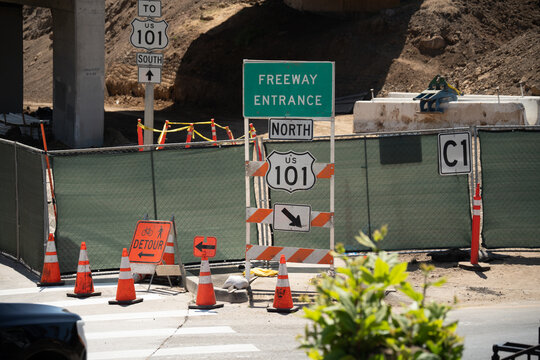 Freeway entrance and detour signs indicate road construction and traffic redirection