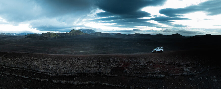 An off-road vehicle crosses the vast volcanic Highlands of Iceland beneath dramatic storm clouds, revealing rugged lava fields, remote wilderness and an unforgettable sense of adventure.