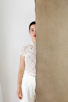 Woman behind torn paper wall 