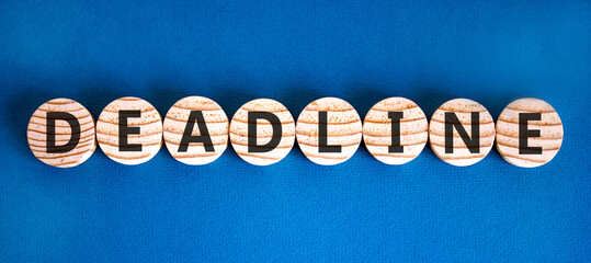 Naklejka premium Deadline word symbol. Concept word Deadline on beautiful wooden circles. Beautiful blue background. Business support help deadline word concept. Copy space.