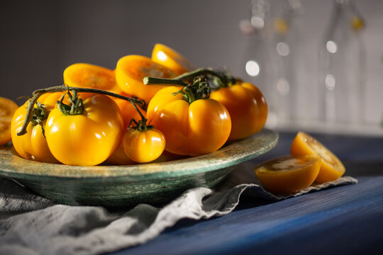 Fresh yellow tomatoes harvesting in a rustic bowl