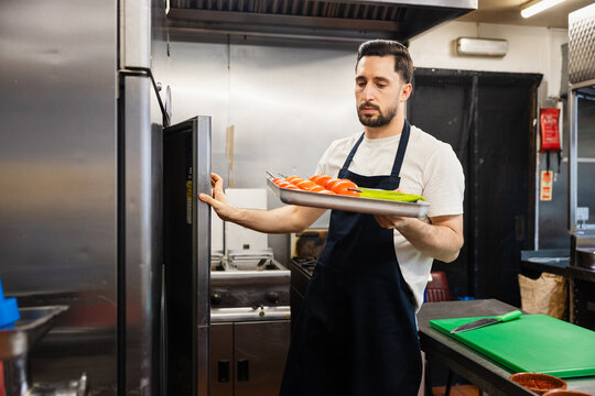 Chef opening fridge with prepared skewers