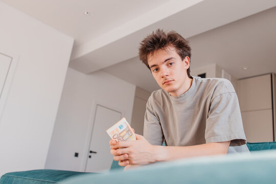 Teenager looking at camera while holding euro banknotes