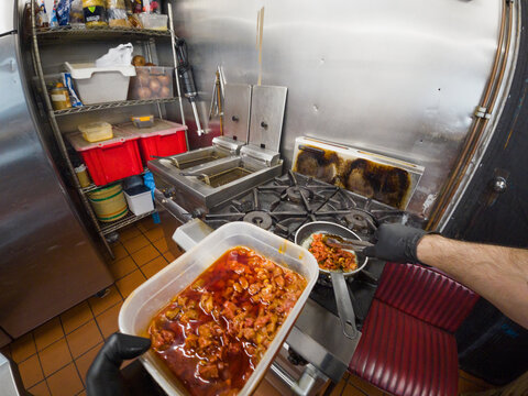POV of chef ladling sauce on stove