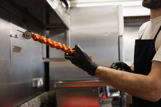 Chef handling a large kebab skewer