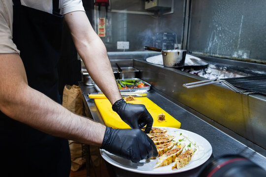 Chef plating Turkish dish with yogurt sauce