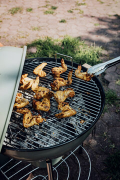 Grilling Chicken Wings Outdoors in a Backyard Setting With Sunlight