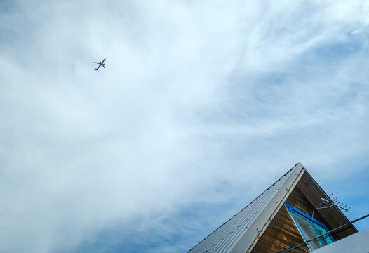 Passenger Plane In The Sky Above The Village