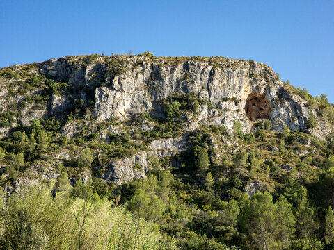 Distant view of steep rocky cliffs and Moorish Caves near Bocairent at midday