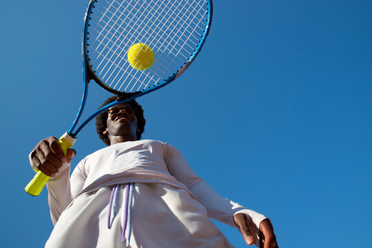 Black man tennis player with racket and ball.