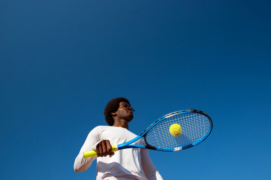 Black man tennis player with racket and ball.