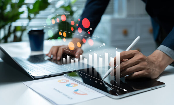 Businessman using digital risk analysis charts on tablet and laptop, visualizing price, risk, market trends, financial data, performance metrics, and strategic decision making.