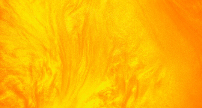 Shimmering gold abstract background. Liquid gold texture waves and swirls. Beautiful shiny yellow texture with glitter. Liquid gold metallic paint close-up.
