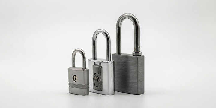 Three padlocks of different sizes standing in a row on a white background