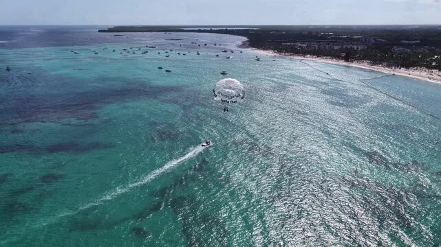Parasailing In Bavaro Punta Cana Dominican Republic. Bird Eye View Of Stunning Parasailing Scene Over A Blue Ocean. Seaside Beach. Tropical Skyline. Bavaro Punta Cana.