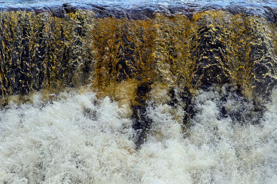 Close up of a waterfall with orange hues