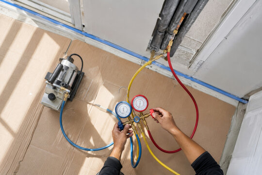 Trabajo de mantenimiento en un sistema de refrigeraci&oacute;n con man&oacute;metros y mangueras en una construcci&oacute;n