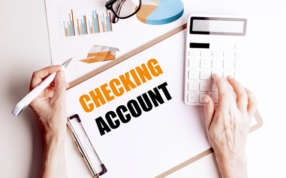 Checking account concept with person using calculator and pen over financial charts and clipboard for banking and money management