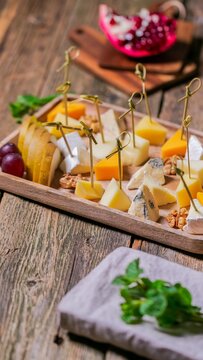 Close up view of colorful fresh fruit platter arranged on rustic wooden board, vibrant tropical fruits suggesting summer gathering or healthy eating ideas for brunch