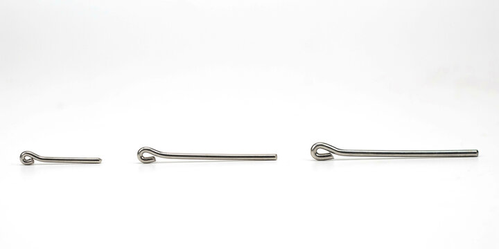 Three silver metal cotter pins of different sizes on a white background