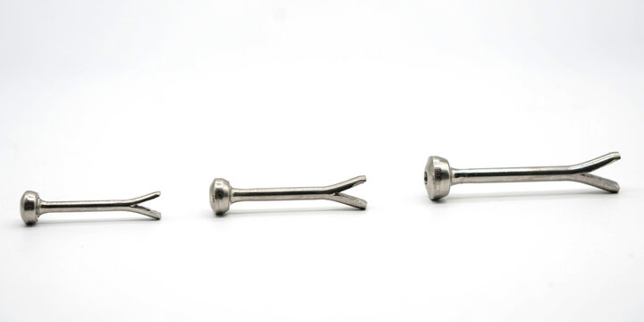 Three silver metal cotter pins of different sizes on a white background