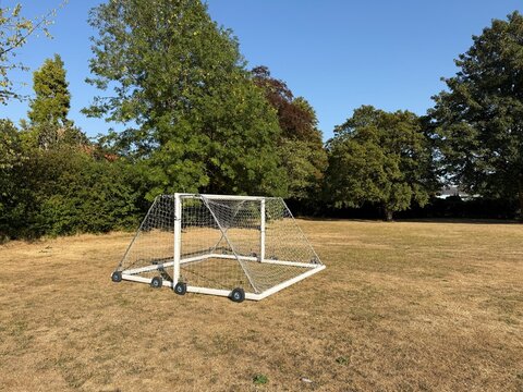 playing field with dried yellowed grass due to the drought this summer in the uk