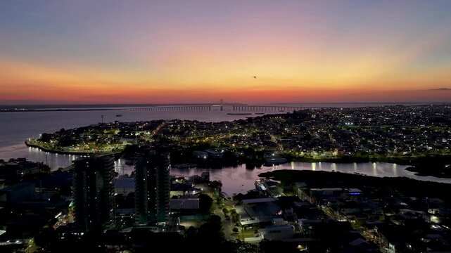 Sunset Cityscape In Manaus Amazonas Brazil. Aerial View Of A River Surrounded By Lush Green Tropical Rainforest. Sunset Golden Hour Skyline. Illumination City. Manaus Amazonas.