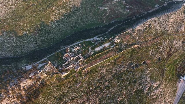 Aerial drone view of the historic ruins of Qal'at Semaan in Syria. Ancient stone architecture and arches at the Church of Saint Simeon Stylites. Famous archaeological site.