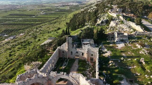 Aerial drone view of the historic ruins of Qal'at Semaan in Syria. Ancient stone architecture and arches at the Church of Saint Simeon Stylites. Famous archaeological site.