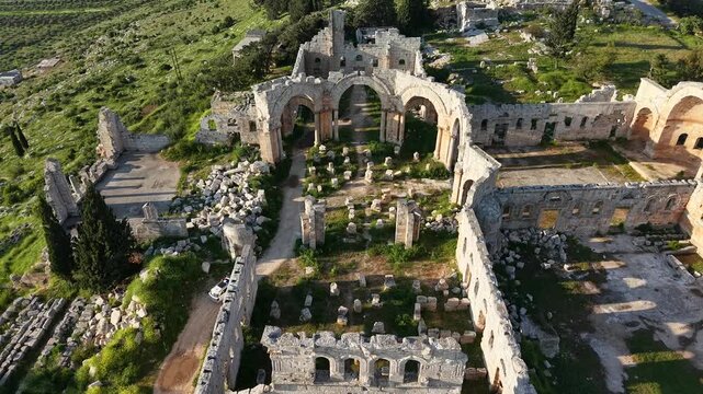 Aerial drone view of the historic ruins of Qal'at Semaan in Syria. Ancient stone architecture and arches at the Church of Saint Simeon Stylites. Famous archaeological site.