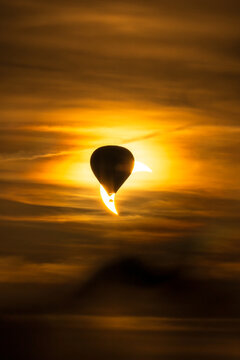 Ein Hei&szlig;luftballon vor einer partiellen Sonnenfinsternis