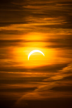 Partielle Sonnenfinsternis hinter weichen Wolken