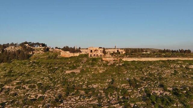 Aerial drone view of the historic ruins of Qal'at Semaan in Syria. Ancient stone architecture and arches at the Church of Saint Simeon Stylites. Famous archaeological site.
