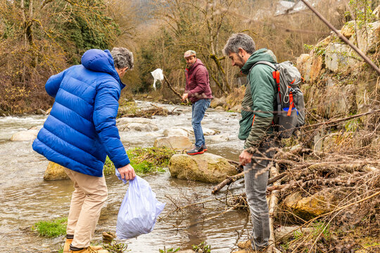 Friends collect plastic waste during river cleanup