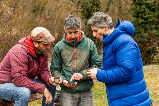 Friends use smartphone during outdoor hike in nature