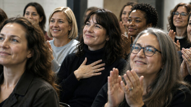 Smiling audience applauding during a conference expressing appreciation, inspiration, connection and shared success