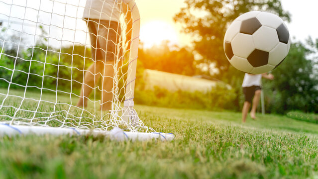Sunlight glows behind a grassy soccer field