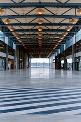 Fototapeta premium Wide empty exhibition hall with diagonal striped floor and overhead lighting for architectural background and event banner design